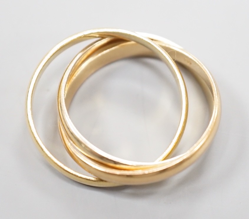 A modern Cartier three colour 750 yellow metal 'Russian' triple wedding ring, size U, 8.5 grams.